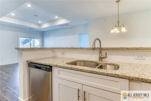 a kitchen with kitchen island granite countertop a sink and chandelier