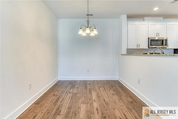 a view of a kitchen with wooden floor and a window