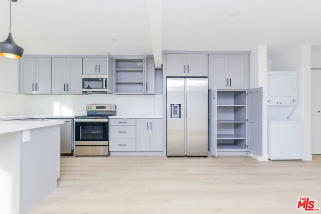a view of a kitchen with refrigerator and a sink