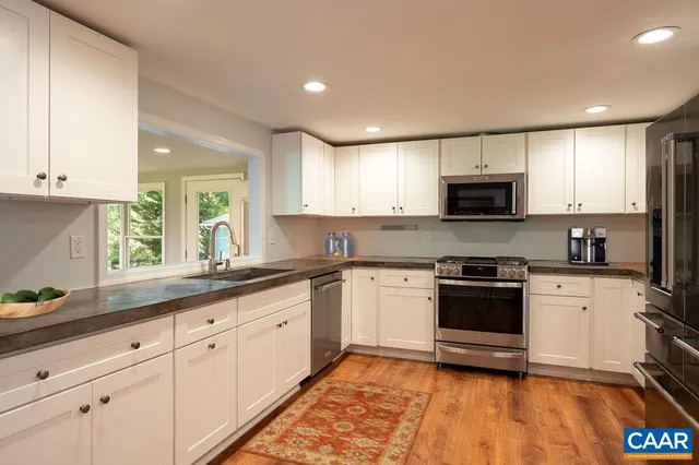 a kitchen with sink a microwave and cabinets