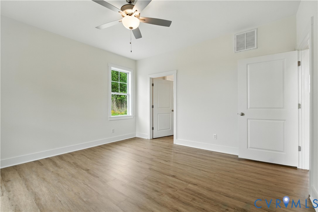 5782 Darlington Heights Road Cullen, VA 23934 - Photo 12 of 21 an empty room with wooden floor chandelier fan and windows