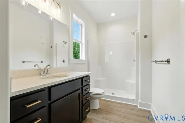 a bathroom with a sink a toilet and shower