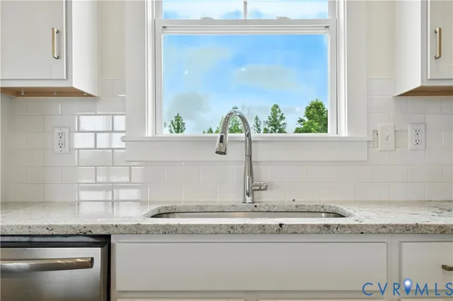 a kitchen with granite countertop stainless steel appliances white cabinets and a granite counter tops