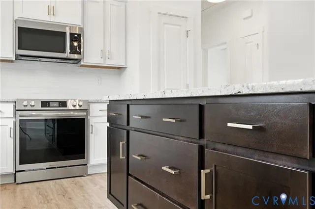 a kitchen with granite countertop white cabinets and oven