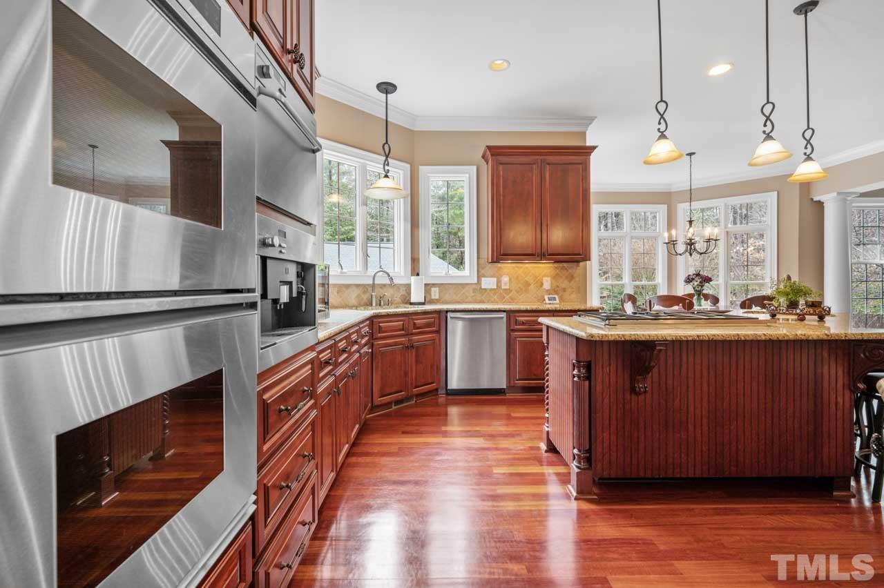 1605 Sharnbrook Court Raleigh, NC 27614 - Photo 28 of 63 a large kitchen with stainless steel appliances granite countertop a stove a sink and a microwave