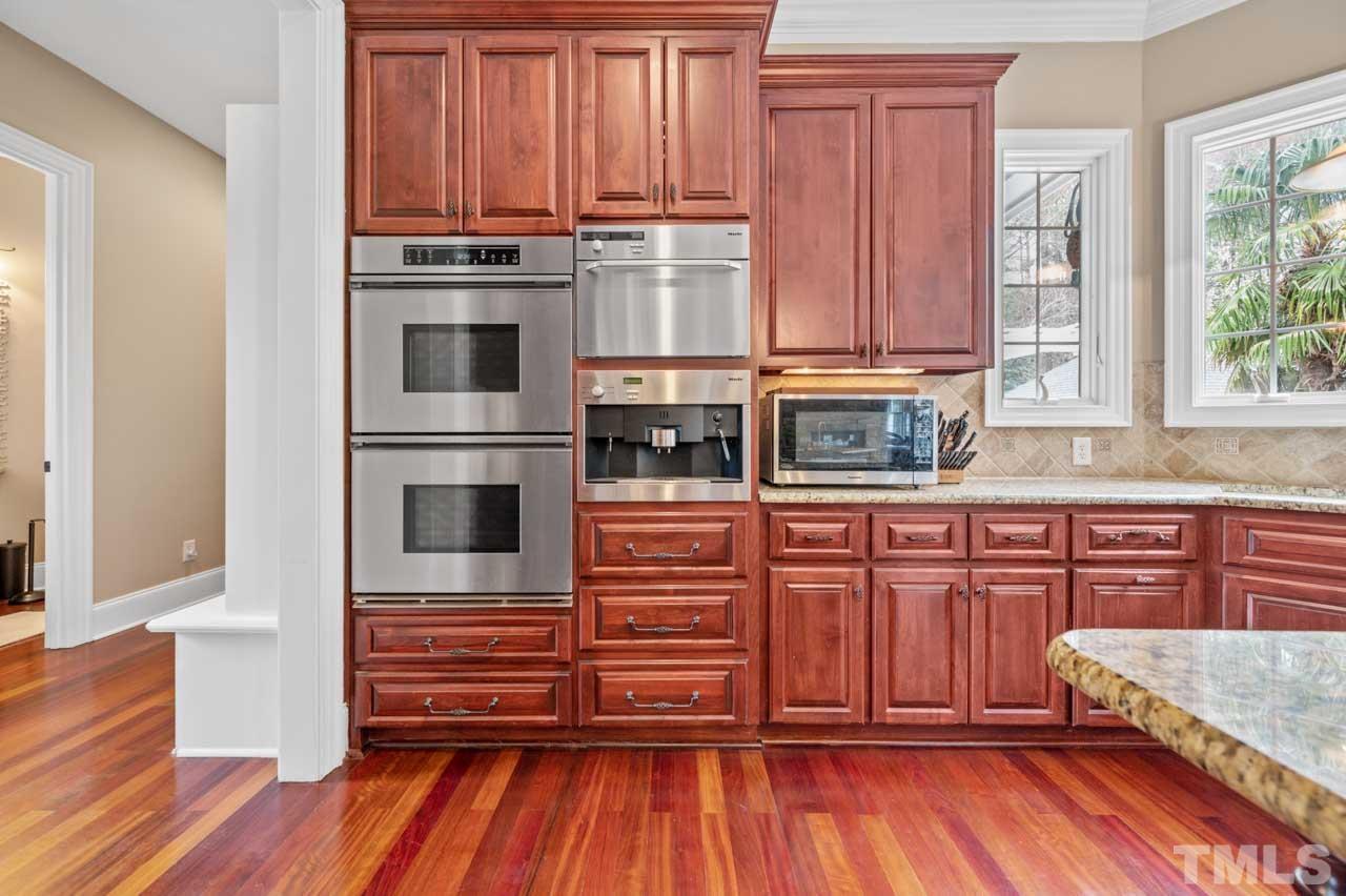 1605 Sharnbrook Court Raleigh, NC 27614 - Photo 29 of 63 a kitchen with stainless steel appliances granite countertop a refrigerator and wooden cabinets