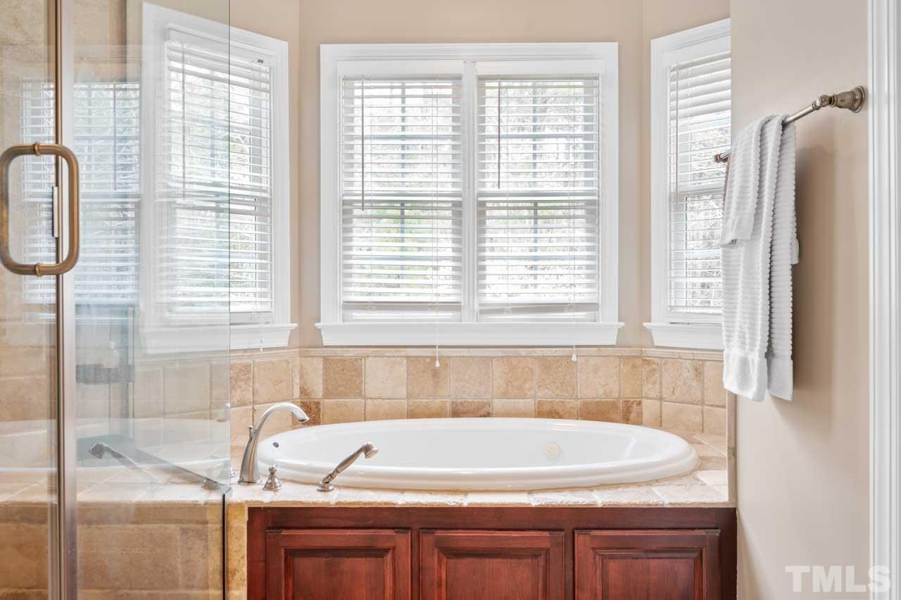 1605 Sharnbrook Court Raleigh, NC 27614 - Photo 46 of 63 a bath tub sitting in a bathroom next to a window