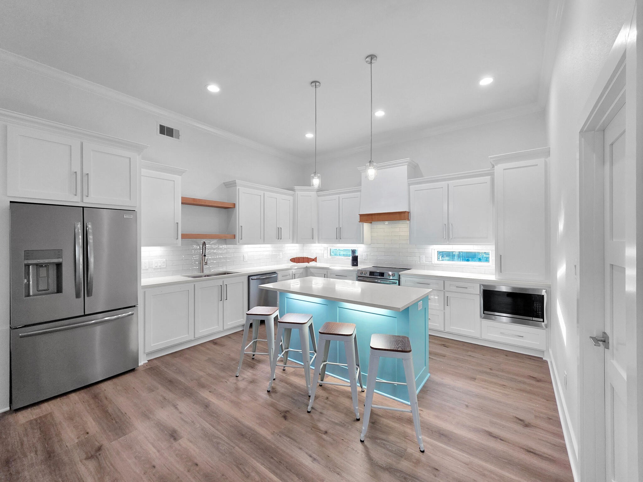 1221 Gulf Road Crystal Beach, TX 77650 - Photo 12 of 48 a kitchen with white cabinets and stainless steel appliances
