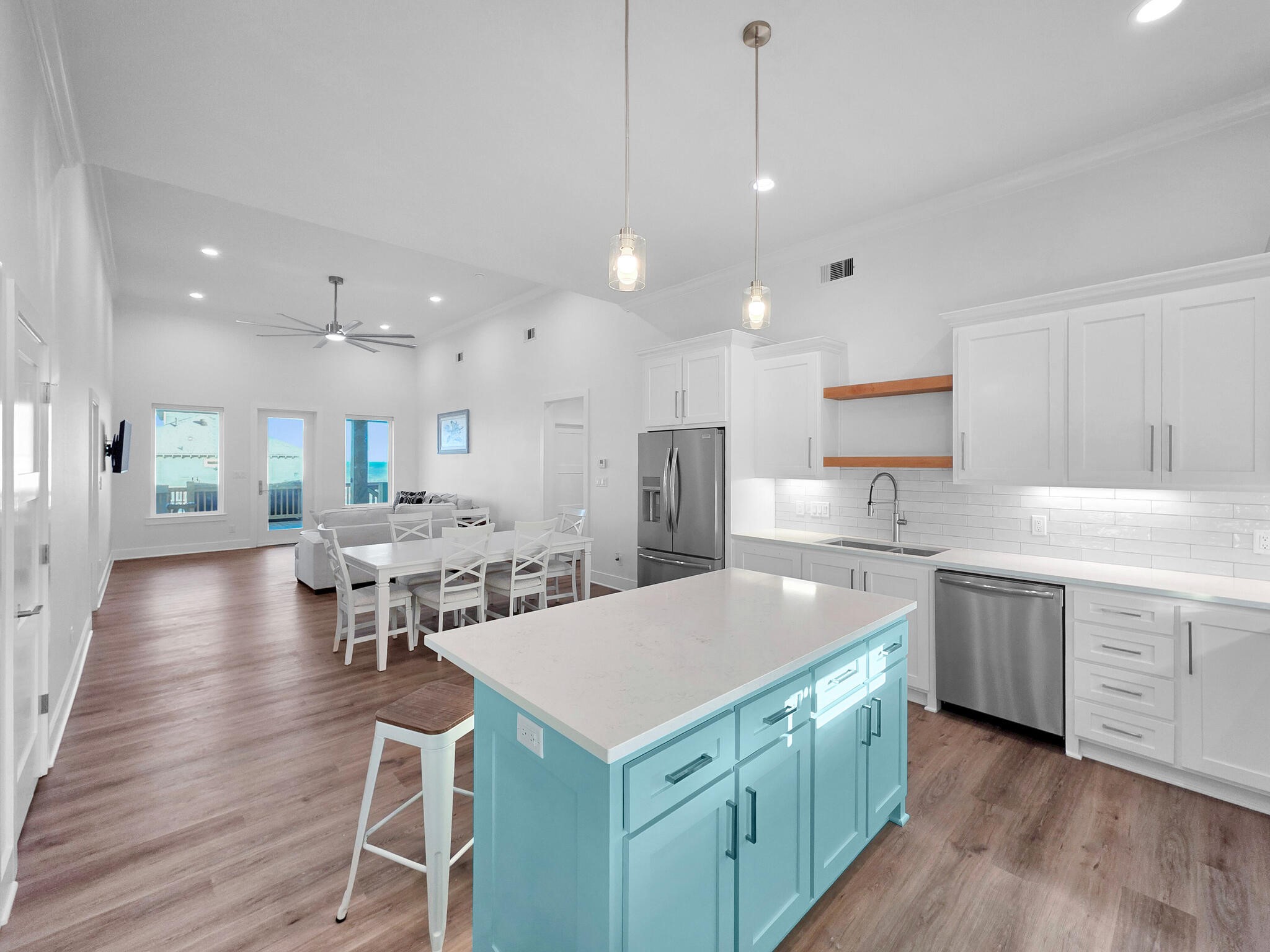 1221 Gulf Road Crystal Beach, TX 77650 - Photo 14 of 48 a kitchen with a dining table chairs refrigerator and white cabinets