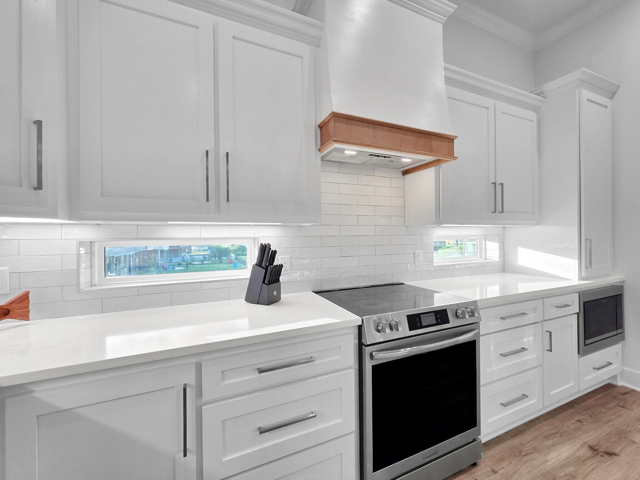 1221 Gulf Road Crystal Beach, TX 77650 - Photo 17 of 48 a kitchen with granite countertop white cabinets and stainless steel appliances
