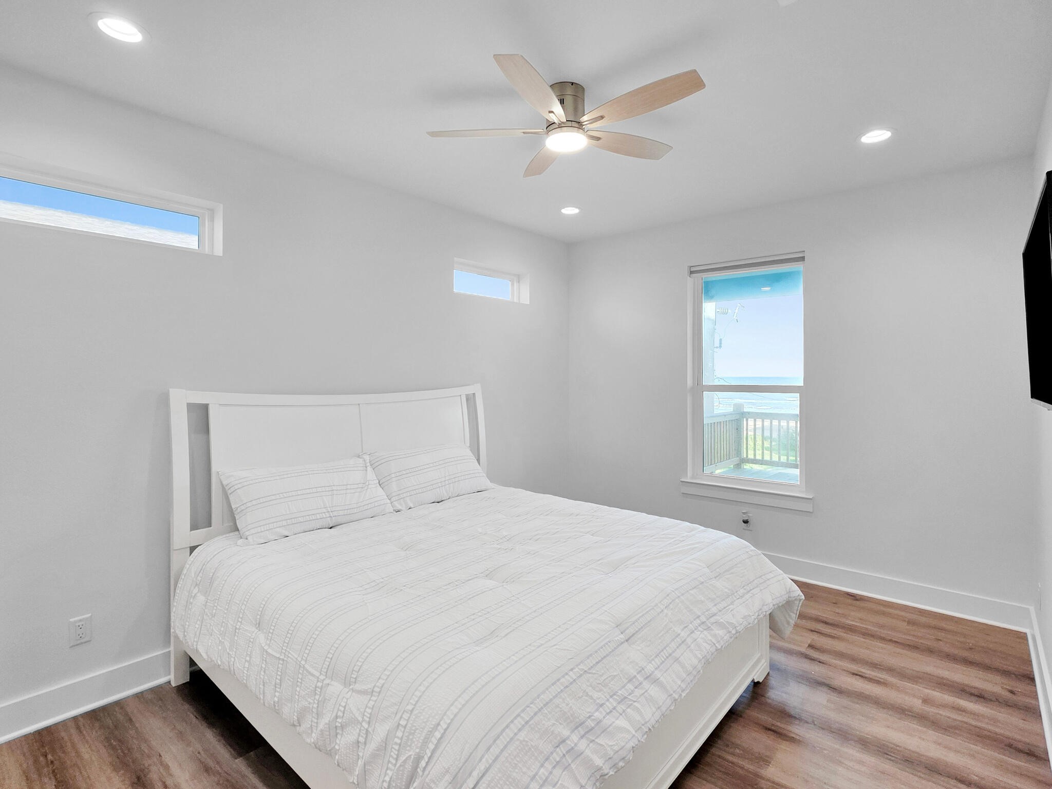 1221 Gulf Road Crystal Beach, TX 77650 - Photo 20 of 48 a large bed sitting in a bedroom next to a window and a chandelier
