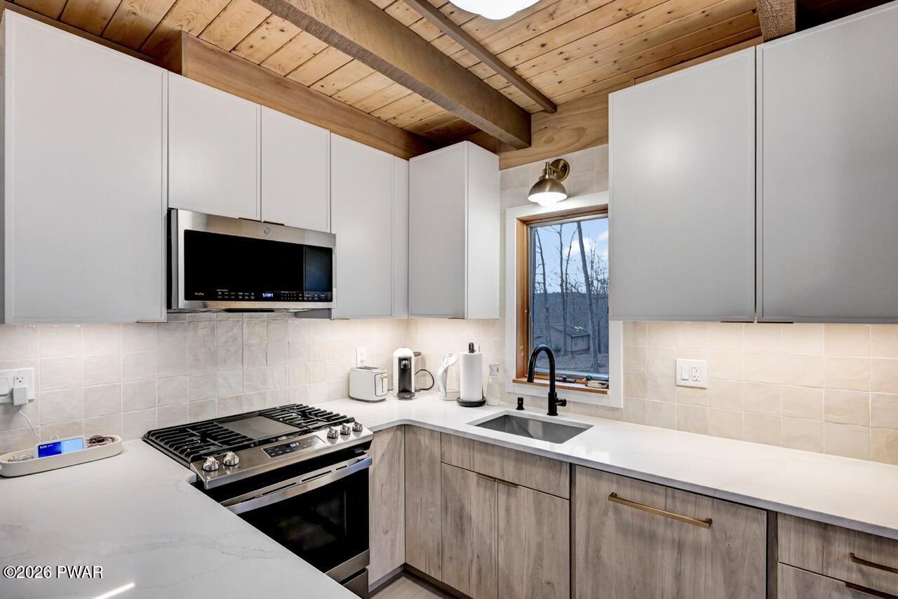 258 Lakeview Road Lackawaxen, PA 18435 - Photo 25 of 119 a kitchen with stainless steel appliances a sink a stove a microwave and cabinets