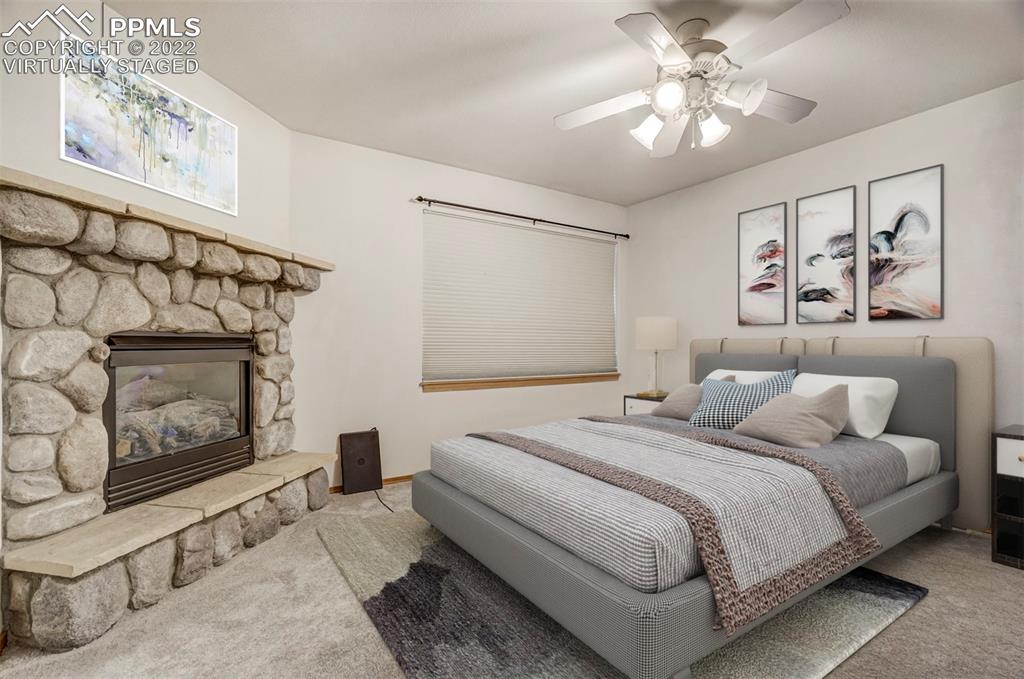 9155 Morgan Road Colorado Springs, CO 80908 - Photo 16 of 41 a bedroom with a bed and a fireplace