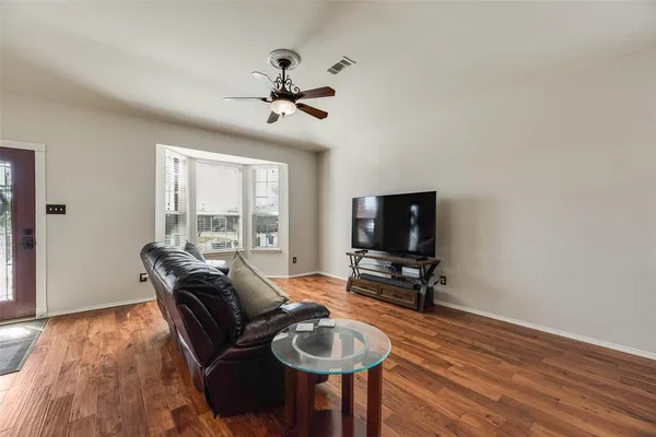 a living room with furniture and a wooden floor