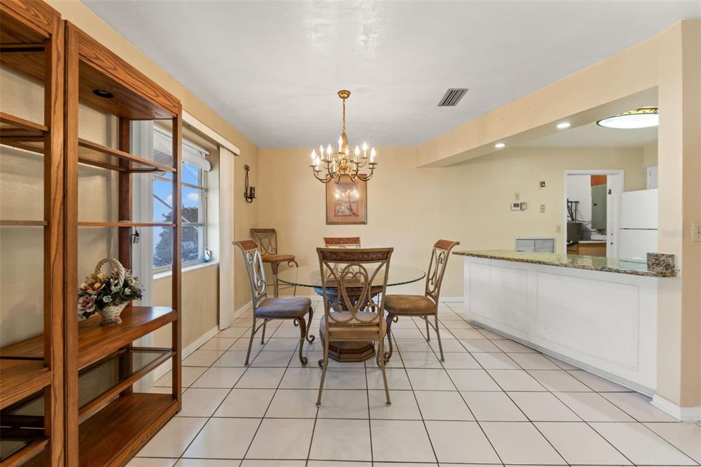 7222 Holiday Drive Spring Hill, FL 34606 - Photo 14 of 50 a dining room filled chandelier and kitchen view
