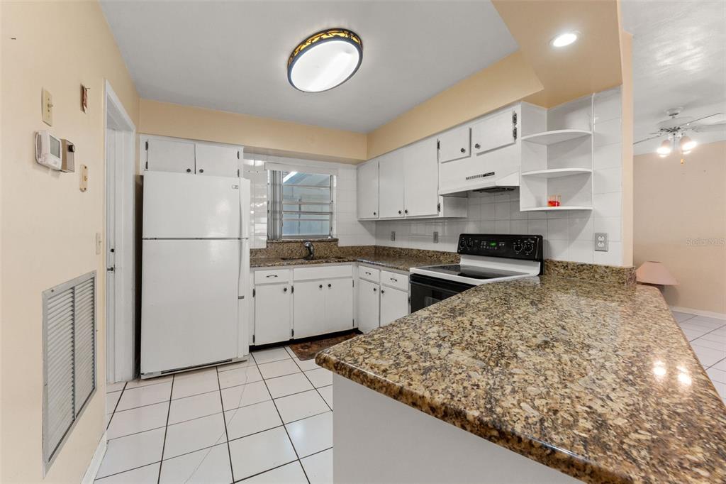 7222 Holiday Drive Spring Hill, FL 34606 - Photo 16 of 50 a kitchen with white cabinets and white appliances