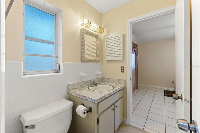 a bathroom with a granite countertop sink a toilet and a mirror