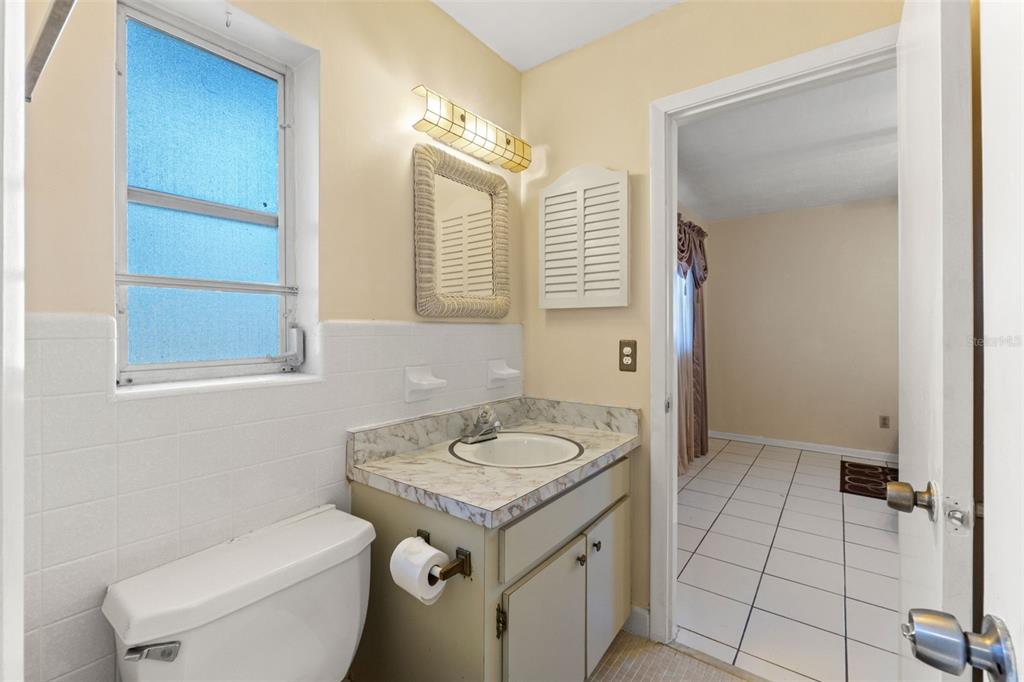 7222 Holiday Drive Spring Hill, FL 34606 - Photo 21 of 50 a bathroom with a granite countertop sink a toilet and a mirror