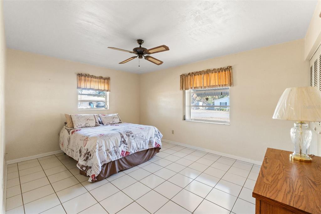 7222 Holiday Drive Spring Hill, FL 34606 - Photo 23 of 50 a spacious bedroom with a bed and a lamp on table