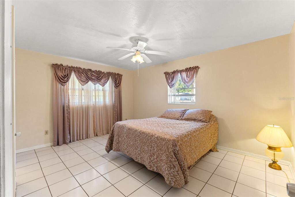 7222 Holiday Drive Spring Hill, FL 34606 - Photo 25 of 50 a bedroom with a bed and a chandelier