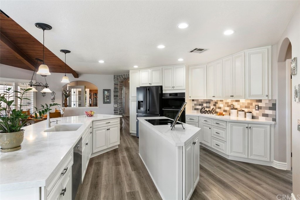 38345 Chaparral Drive Temecula, CA 92592 - Photo 12 of 43 a kitchen with stainless steel appliances kitchen island granite countertop a table chairs and a refrigerator