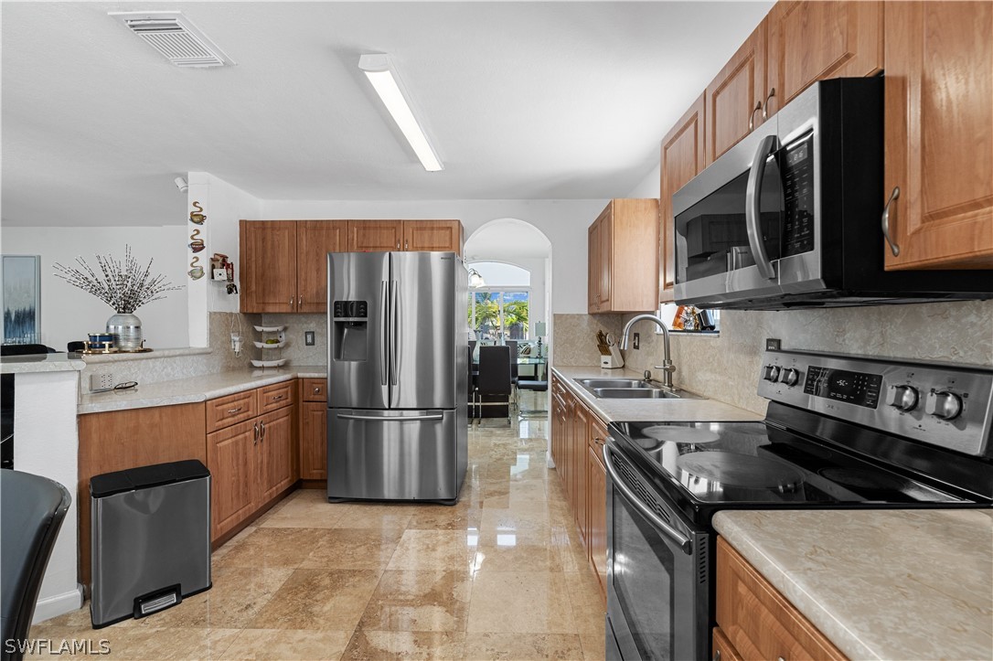 13302 Southwest 283rd Street Homestead, FL 33033 - Photo 19 of 43 a kitchen with stainless steel appliances granite countertop a stove top oven a sink dishwasher a refrigerator and a microwave