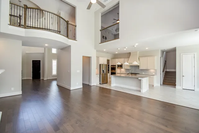 a view of a white house with a big yard and potted plants