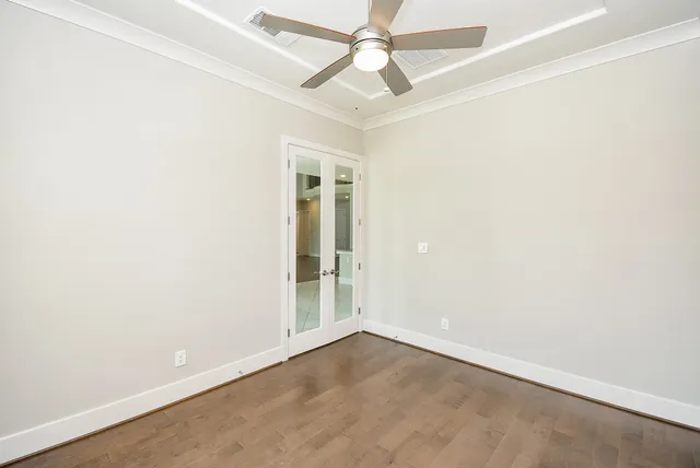 an empty room with a window and a fan