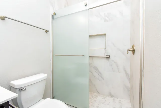 an empty room with a ceiling fan and wooden floor