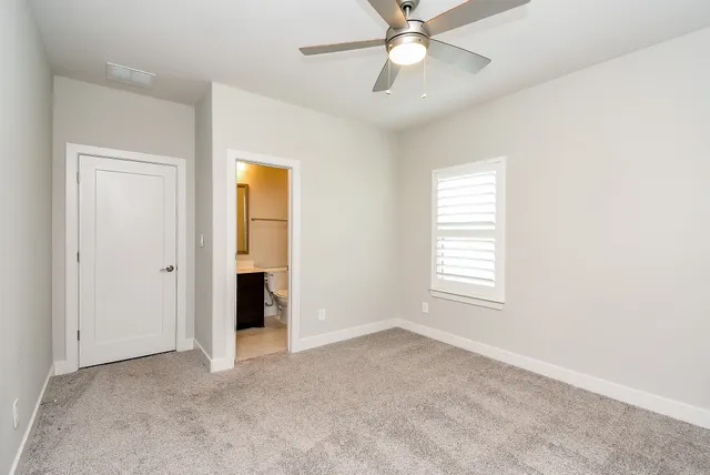 an empty room with a window and a fan