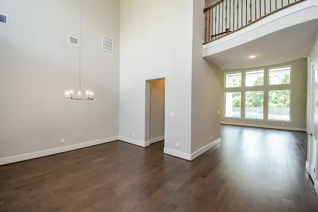 an entryway of a room with wooden floor and windows