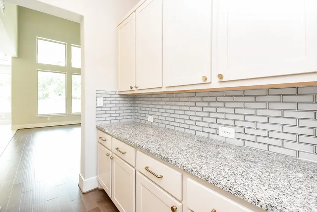view of kitchen with granite countertop cabinets and window