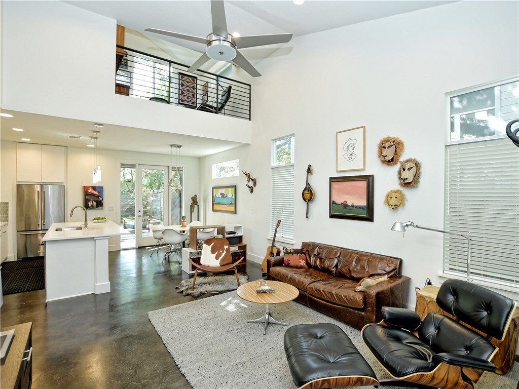 a living room with furniture kitchen view and a chandelier