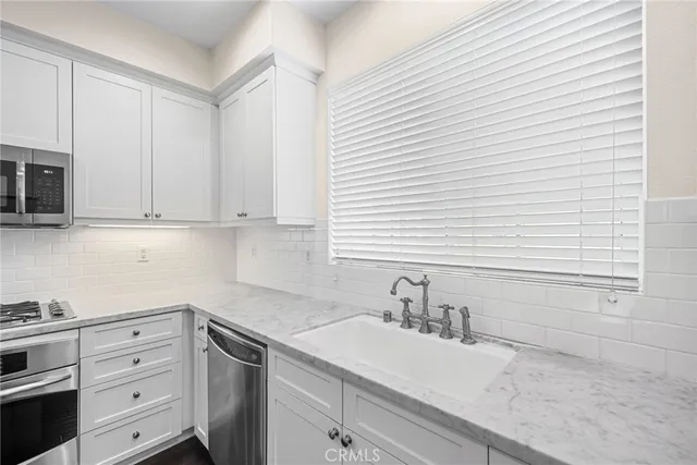 a kitchen with granite countertop white cabinets and white appliances