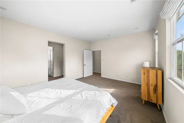 a bedroom with a bed and a refrigerator