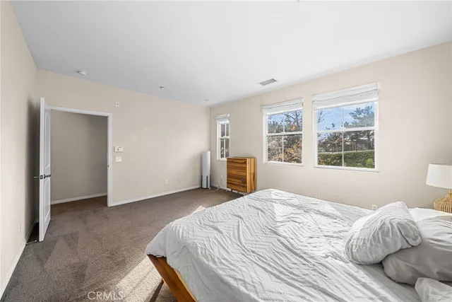 a bedroom with a bed and a large window