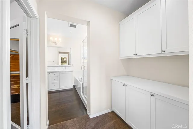 a view of a kitchen with white cabinets and a window