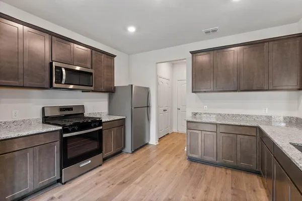 a kitchen with stainless steel appliances wooden cabinets and a stove top oven