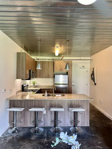 a kitchen with stainless steel appliances wooden cabinets and wooden floor