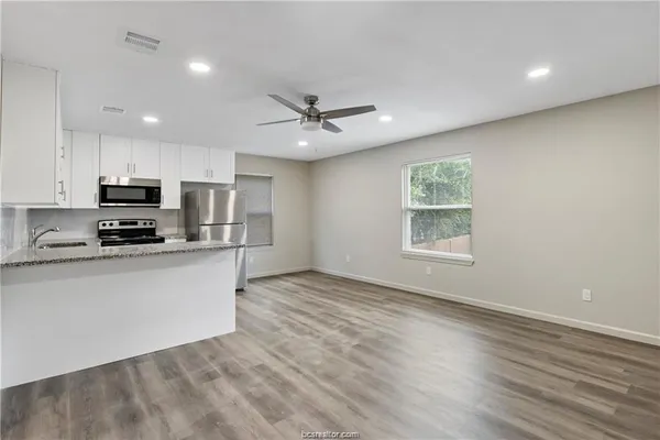 a view of kitchen with sink microwave and stove top oven