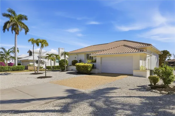 a view of a house with outdoor space and palm trees