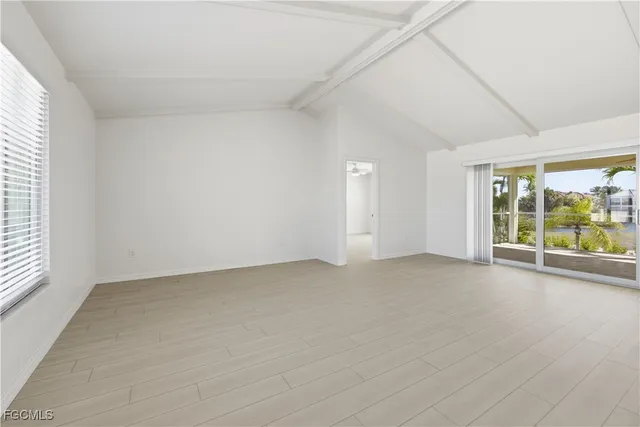 a view of a big room with wooden floor and windows