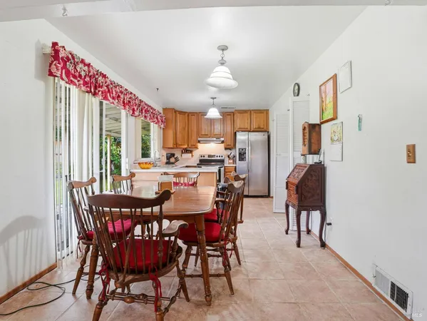 a dining room with furniture a chandelier and window