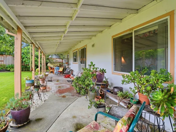 a view of a patio with table and chairs potted plants