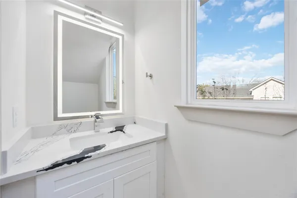 a bathroom with a granite countertop sink and a mirror