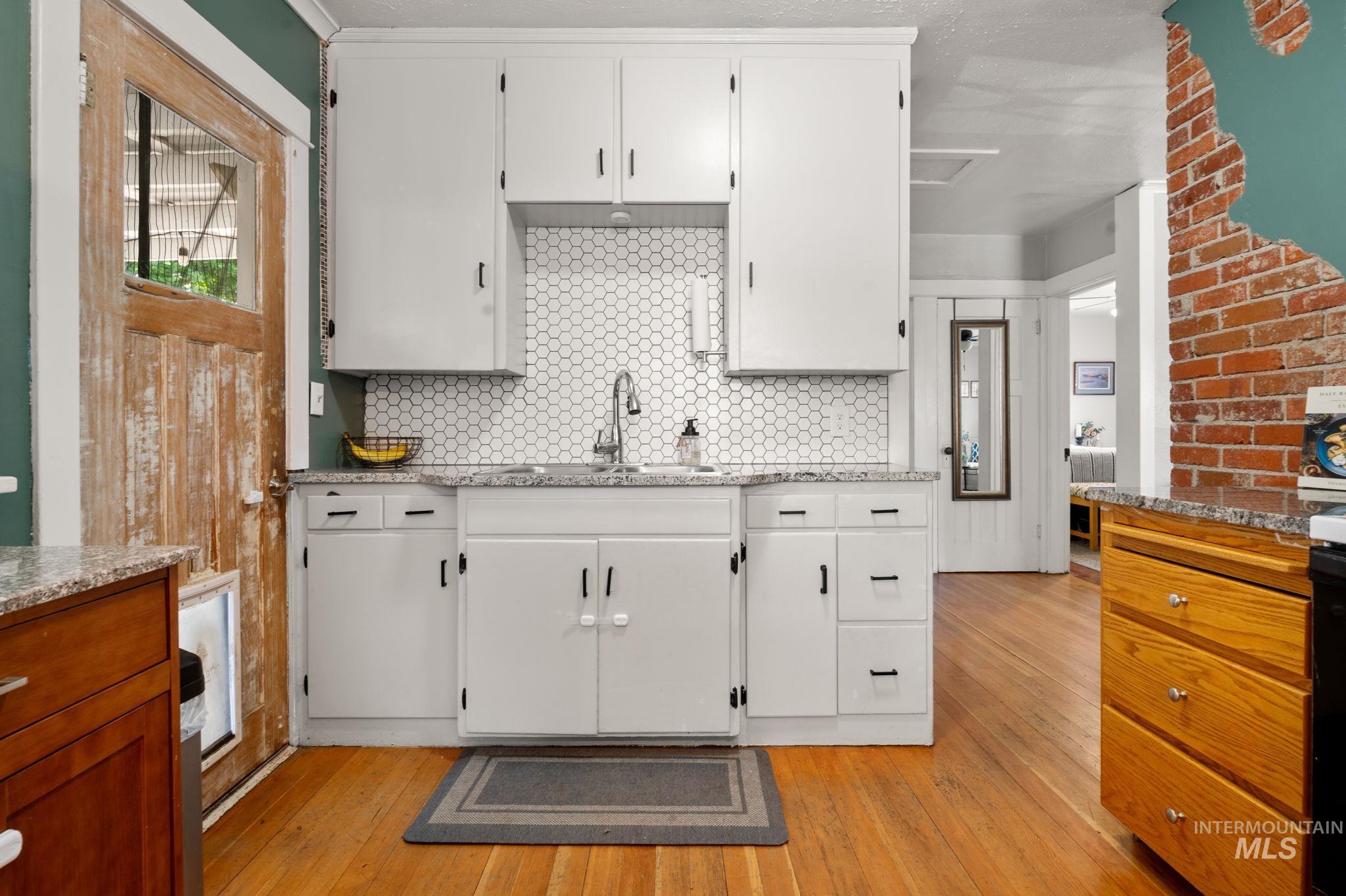 907 3rd Street Lewiston, ID 83501 - Photo 11 of 26 Kitchen with white cabinetry, light wood-type flooring, and light stone counters