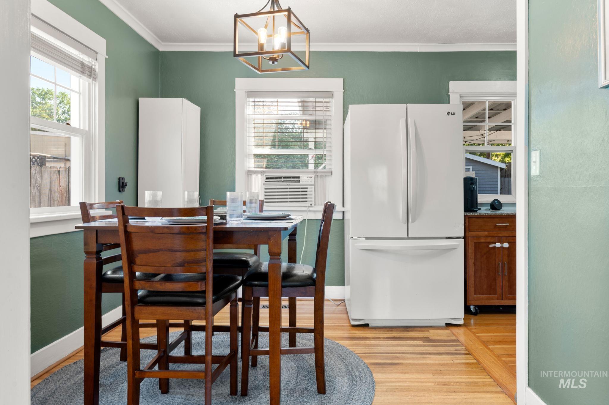 907 3rd Street Lewiston, ID 83501 - Photo 12 of 26 Dining space with a chandelier, plenty of natural light, light wood-style floors, crown molding, and cooling unit