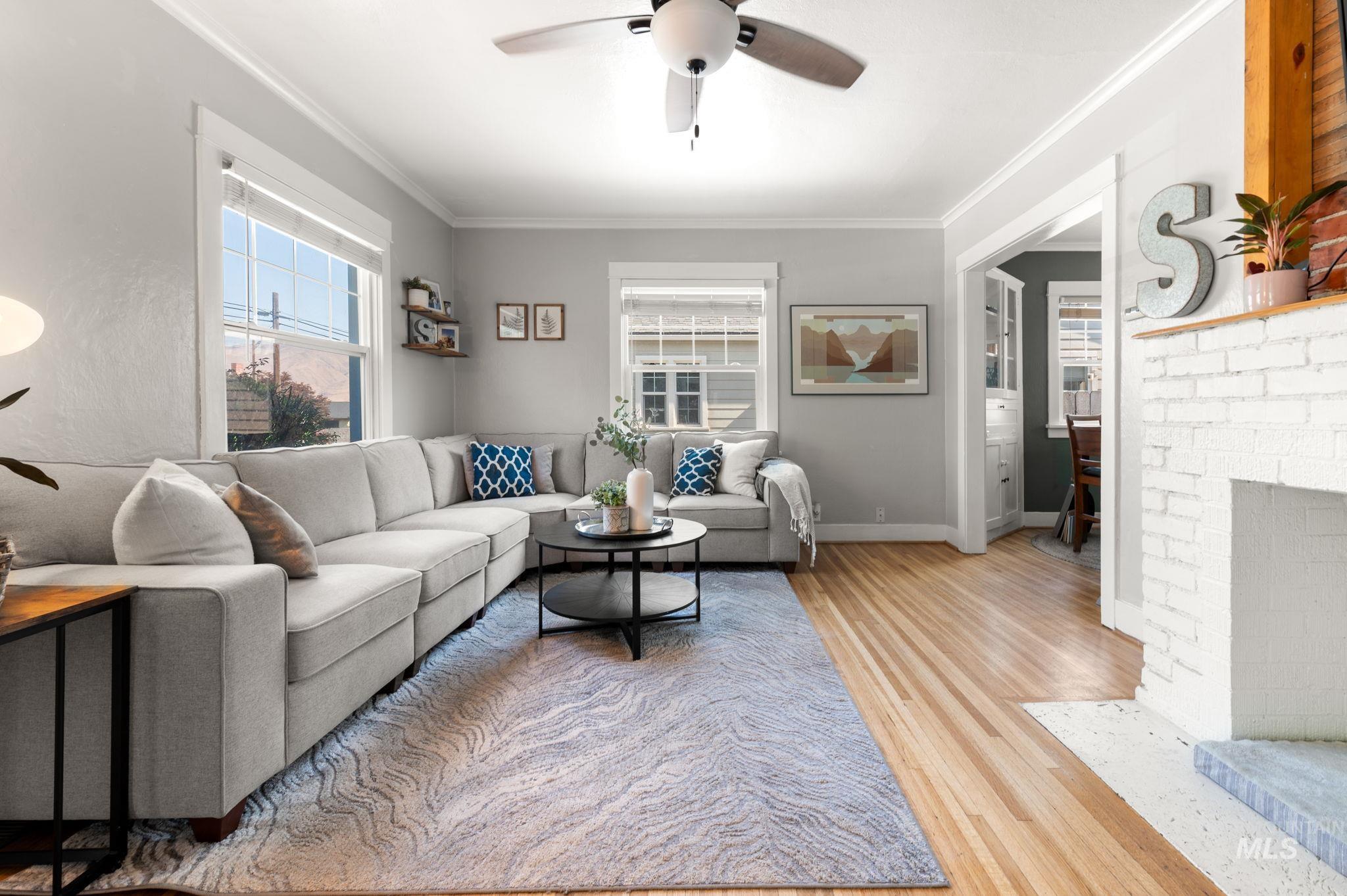 907 3rd Street Lewiston, ID 83501 - Photo 20 of 26 Living area featuring ceiling fan, a fireplace, light wood-type flooring, and crown molding