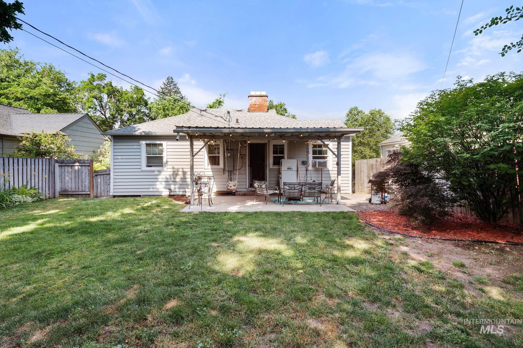 907 3rd Street Lewiston, ID 83501 - Photo 24 of 26 Rear view of house featuring a fenced backyard, a chimney, and a patio area