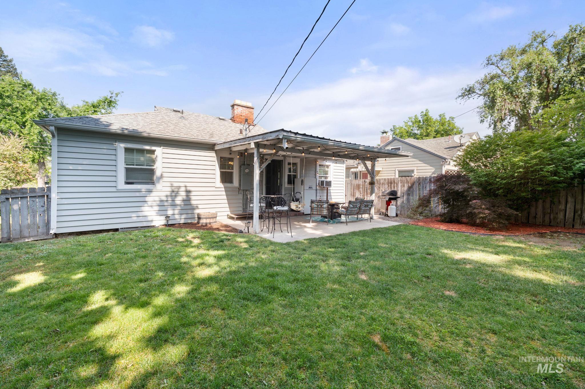 907 3rd Street Lewiston, ID 83501 - Photo 26 of 26 Rear view of house featuring a fenced backyard, a chimney, a patio area, and a shingled roof